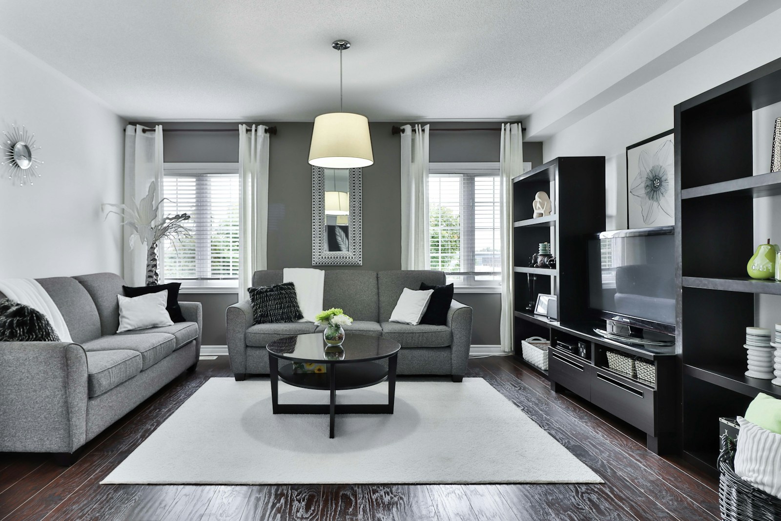 Intricately patterned Persian silk rug laid out on herringbone parquet floor in airy modern salon